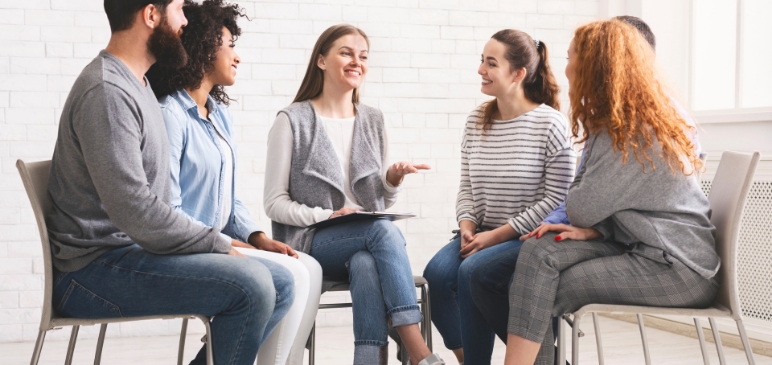A group of people sitting in a circle and speaking