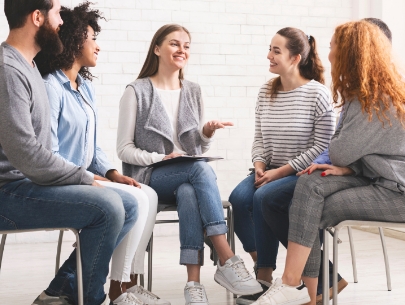 A group of people sitting in a circle and speaking