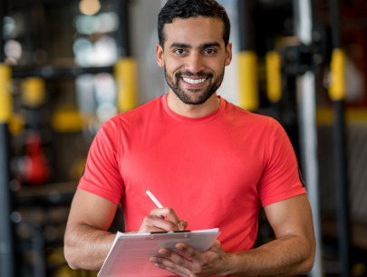Man in red shirt writing on a clipboard
